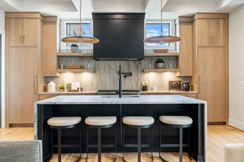 a large kitchen with stainless steel appliances kitchen island granite countertop a sink and cabinets