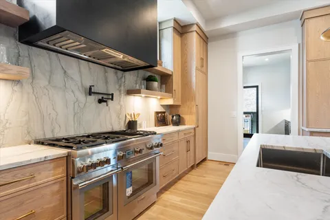 a large kitchen with cabinets wooden floor and stainless steel appliances