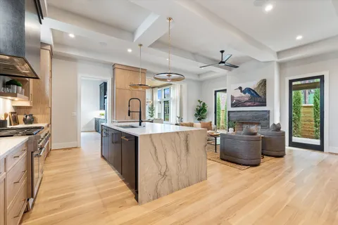 a view of a dining room with furniture a chandelier and large windows