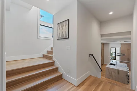 a view of a hallway with wooden floor and windows