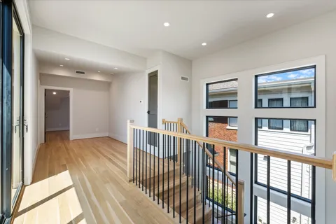 a view of a balcony with a large window and wooden floor