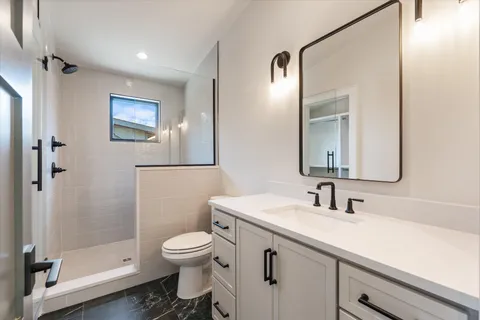 a spacious bedroom with a bed and wooden floor