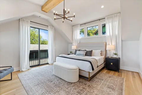a bedroom with a large bed and a chandelier