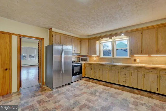a kitchen with granite countertop a refrigerator and a sink