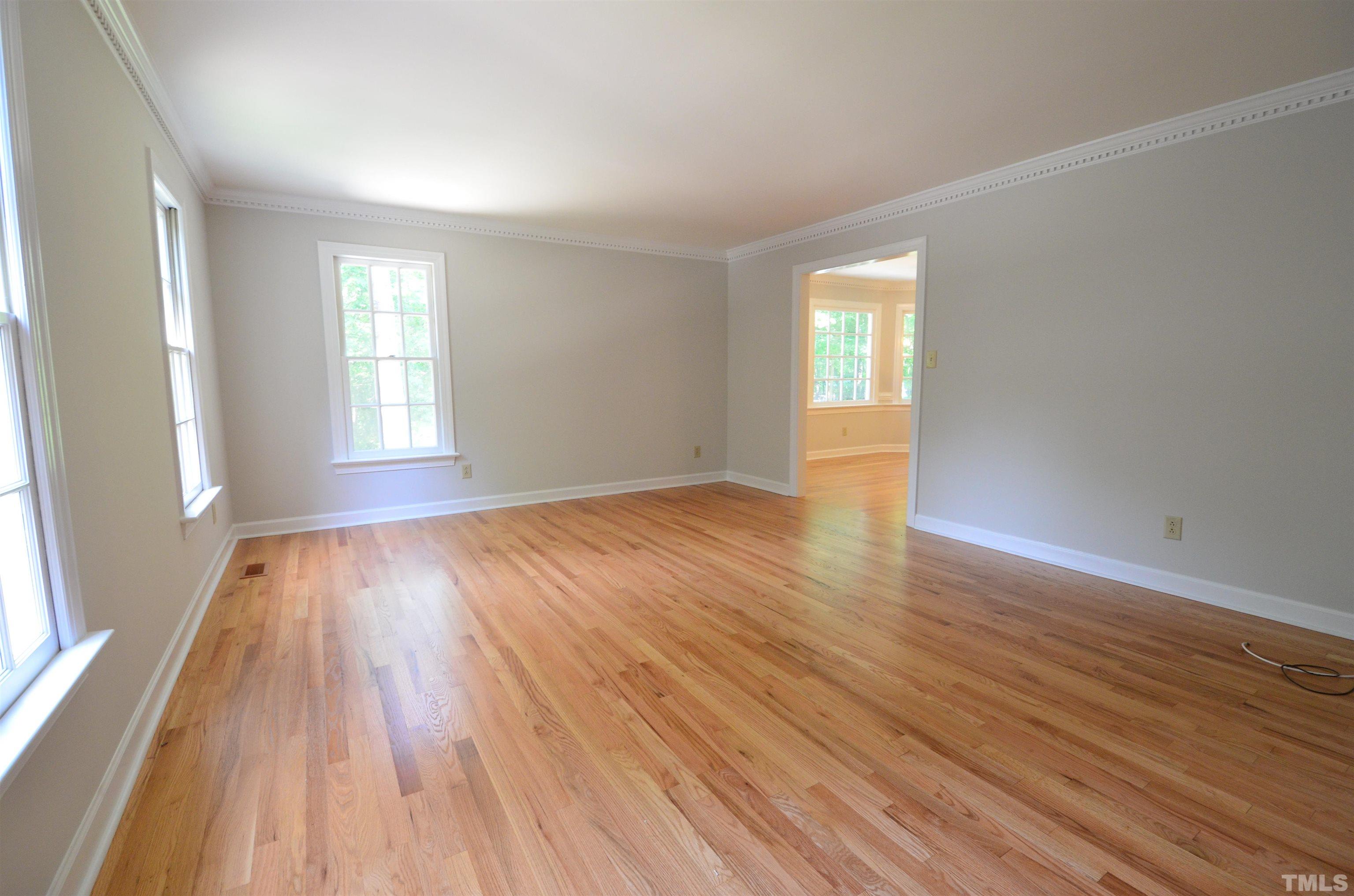 224 Jansmith Lane Raleigh, NC 27615 - Photo 8 of 27 an empty room with wooden floor and windows