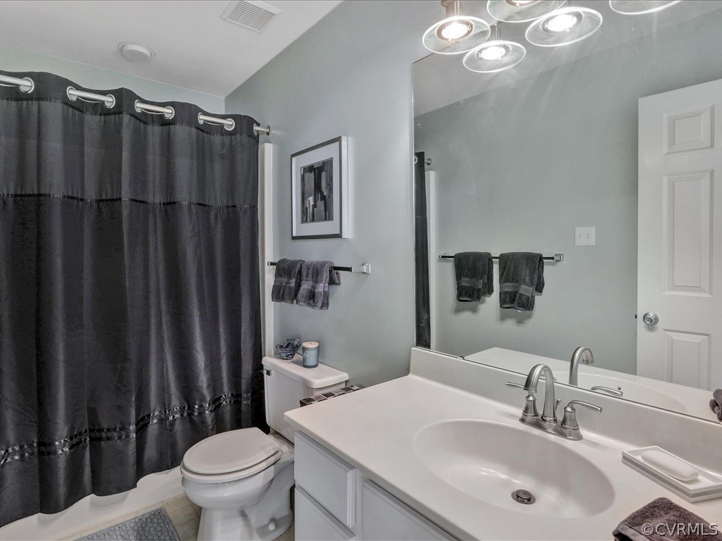 13804 Sandy Oak Road Chester, VA 23831 - Photo 25 of 31 a bathroom with a sink a toilet a mirror and shower curtain