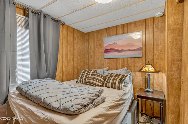 a bedroom with a bed and a painting on the wall