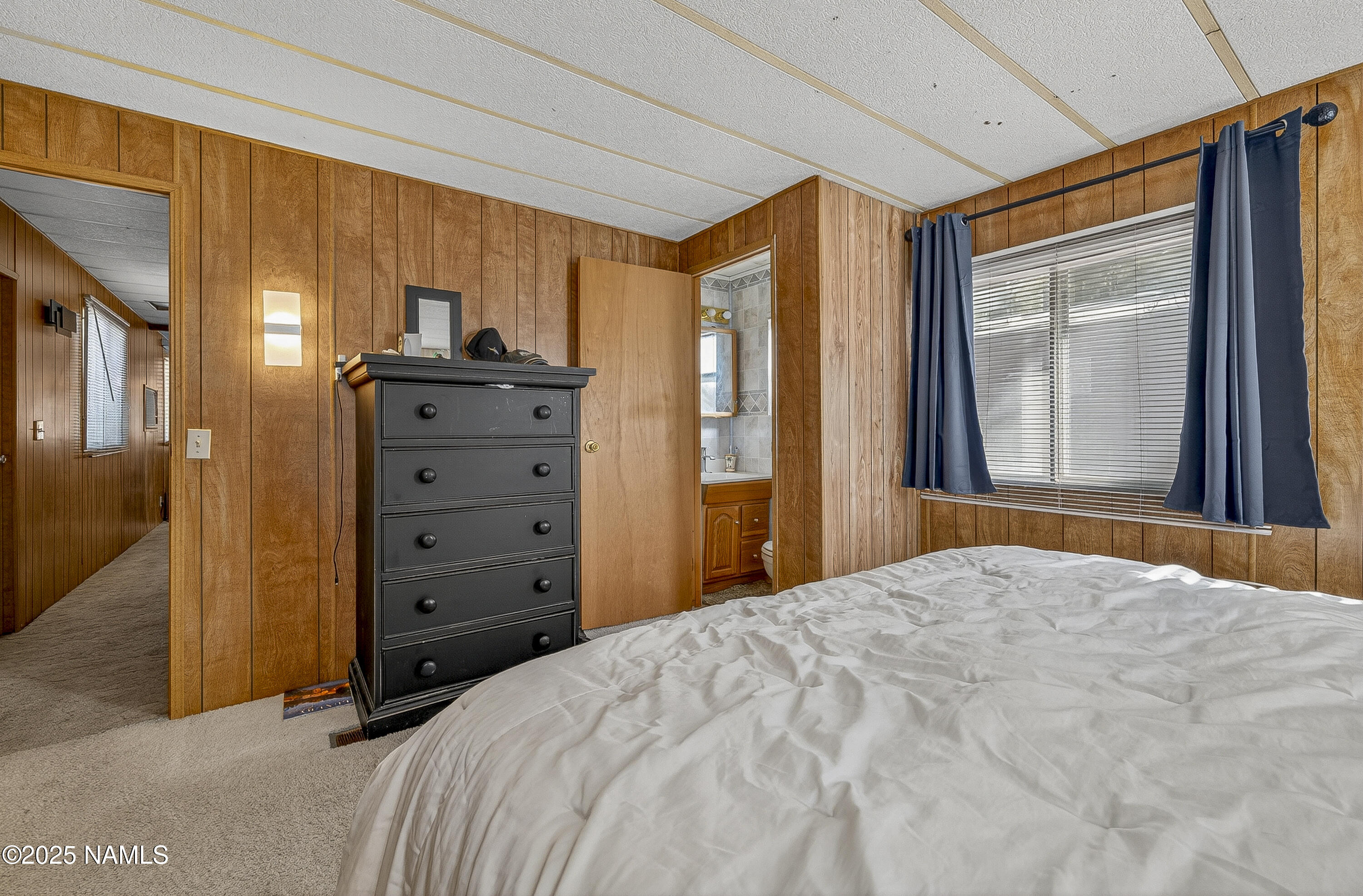 2500 West Rte 66, Unit 83 Flagstaff, AZ 86001 - Photo 15 of 24 a bedroom with a bed and large windows