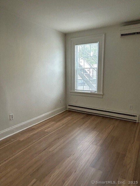 110 East Avenue, Unit 1 Norwalk, CT 06851 - Photo 4 of 11 an empty room with wooden floor and windows