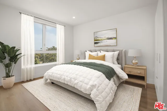 a bedroom with a large bed and a large window