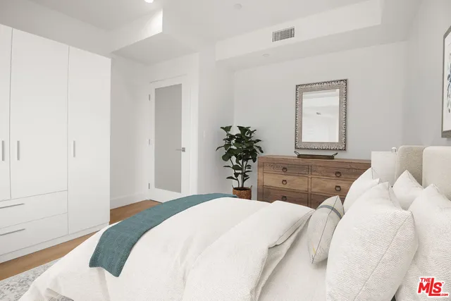 a bedroom with a bed and a potted plant