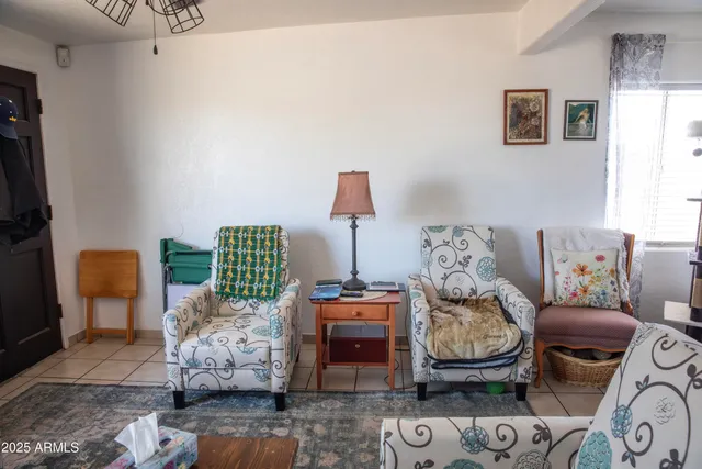 a living room with furniture a flat screen tv and a window