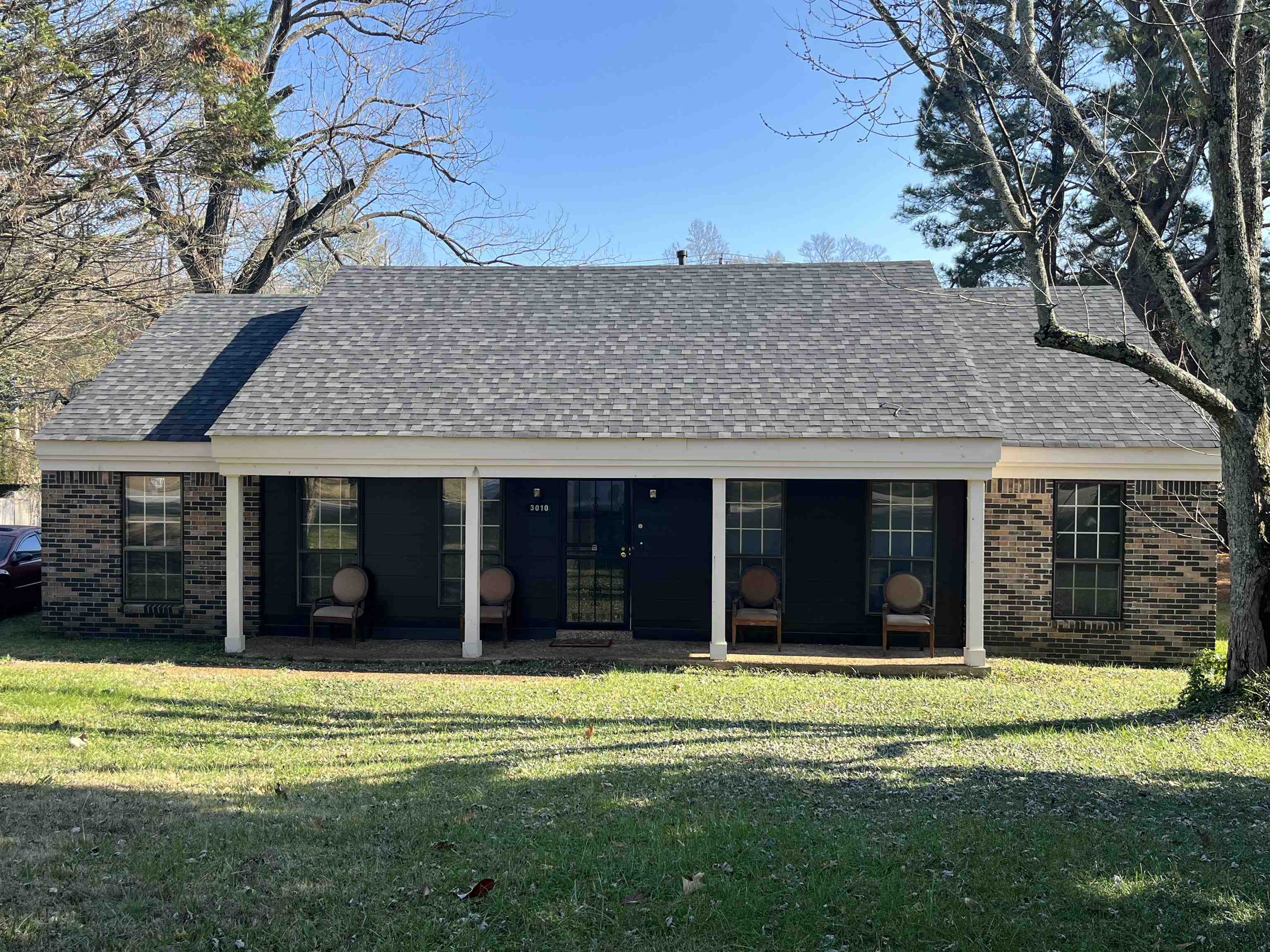 3010 Falkirk Road Memphis, TN 38128 - Photo 2 of 13 Rear view of house with roof with shingles, a lawn, brick siding, and a patio