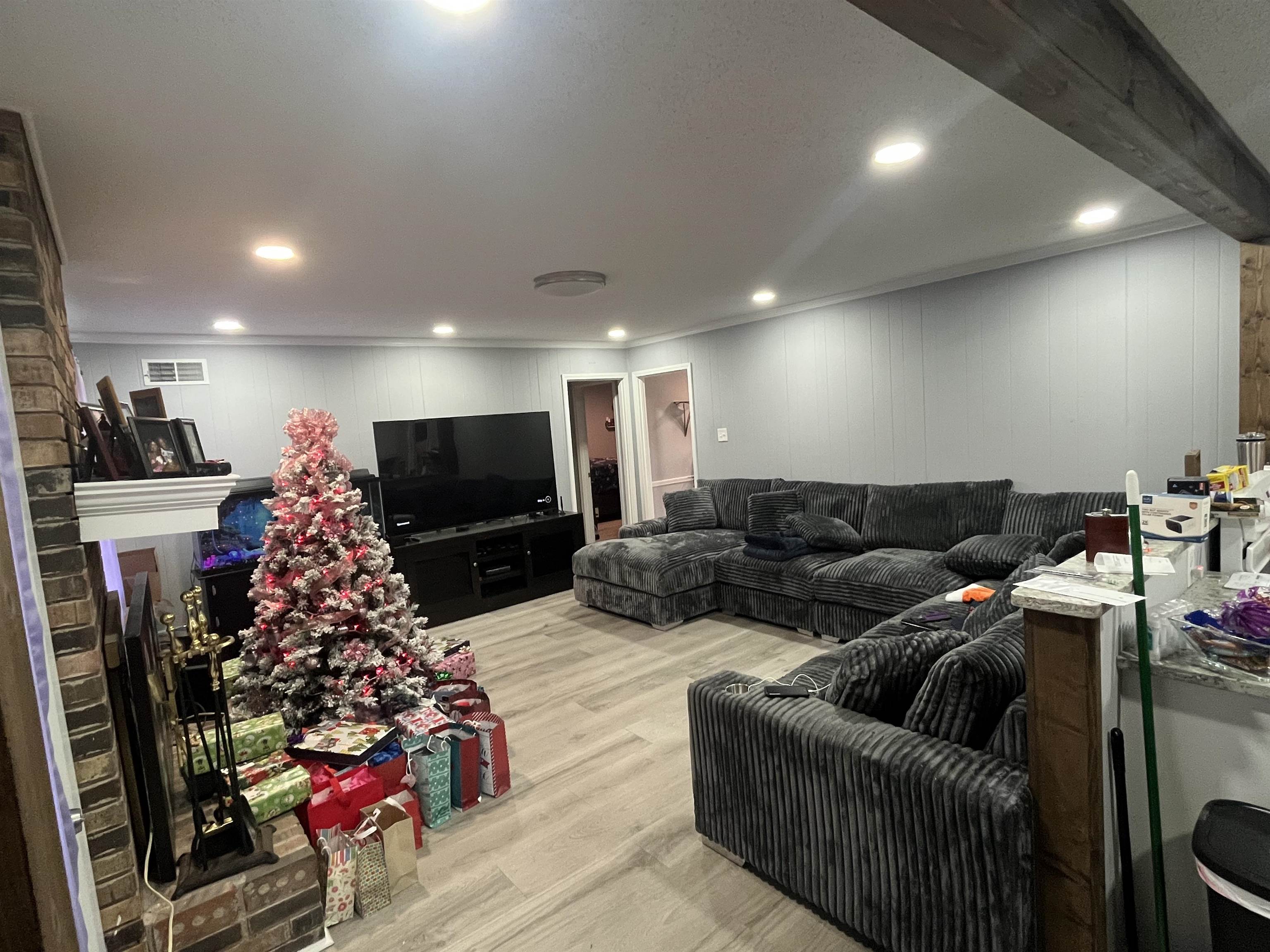 3010 Falkirk Road Memphis, TN 38128 - Photo 5 of 13 Living area featuring light wood finished floors, a brick fireplace, and wood walls