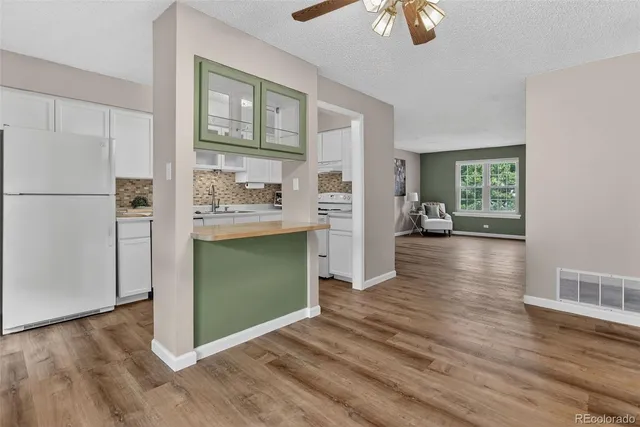 a view of a kitchen with wooden floor electronic appliances and window
