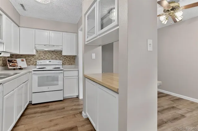 a kitchen with granite countertop white cabinets and white appliances