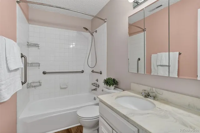 a bathroom with a granite countertop sink a toilet and a bathtub