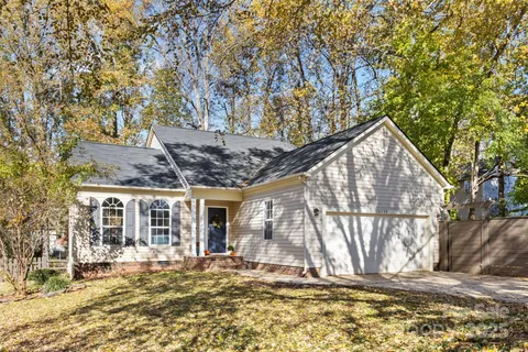 a backyard of a house with large trees and outdoor seating