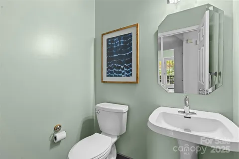 a bathroom with a toilet a sink and mirror