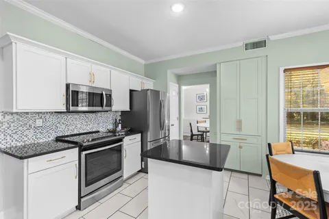 a kitchen with stainless steel appliances granite countertop a stove microwave and refrigerator