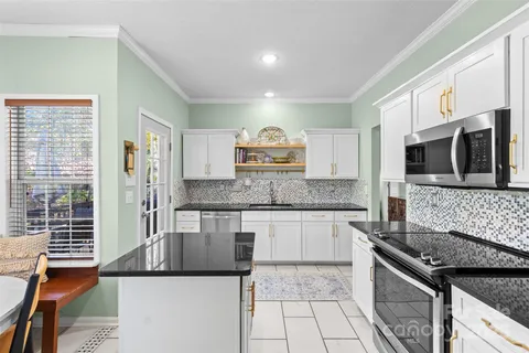 a kitchen with stainless steel appliances granite countertop a stove and a microwave