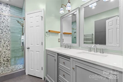a bathroom with a granite countertop sink a large mirror and shower
