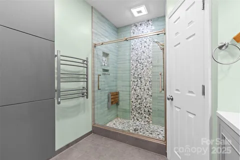 a bathroom with a glass shower door and a sink