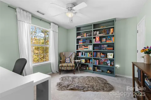 a living room with furniture and a book shelf