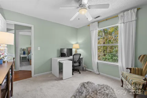 a view of a livingroom with workspace and a window