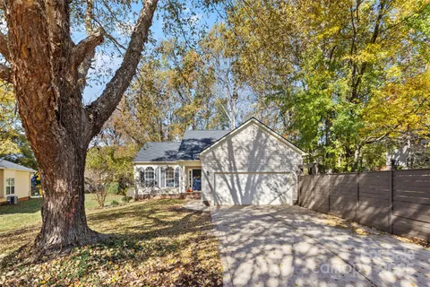a view of a yard in front of a house with large tree