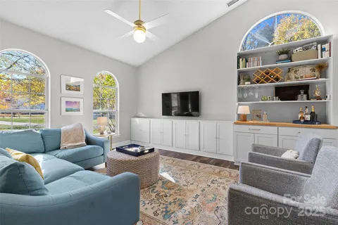 a living room with furniture a flat screen tv and a large window