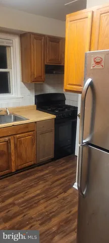 a kitchen with a refrigerator sink and cabinets