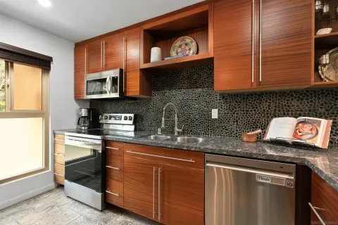 a kitchen with stainless steel appliances granite countertop a sink and a stove