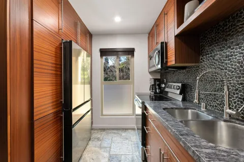a kitchen with kitchen island granite countertop a sink stainless steel appliances a counter top space and cabinets