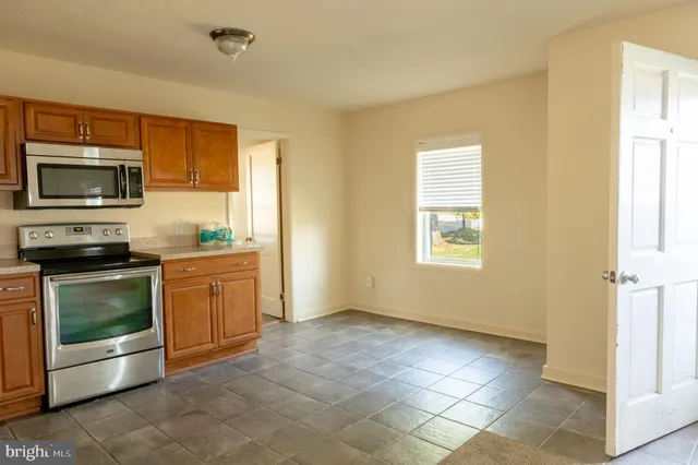 a kitchen with a stove top oven cabinets and a refrigerator