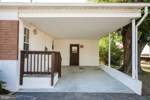 a view of an empty room with wooden floor and floor to ceiling windows