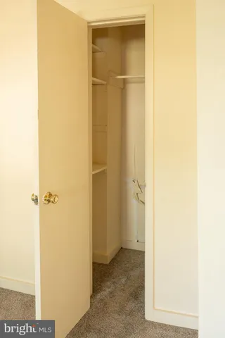 a view of a hallway with wooden floor and a livingroom