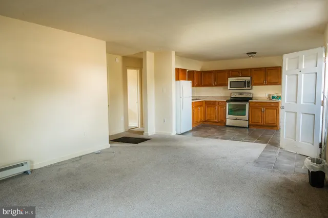 a view of a kitchen with a sink and dishwasher a refrigerator with white cabinets