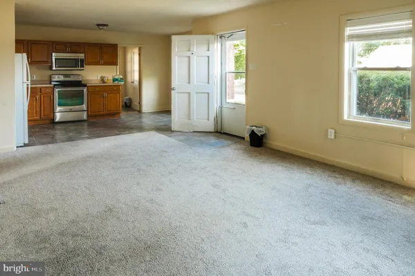 a view of a kitchen with refrigerator and window