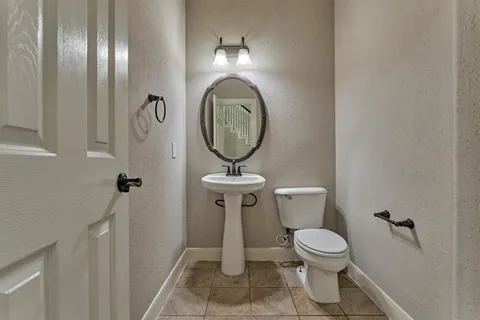 a bathroom with a toilet a sink and mirror
