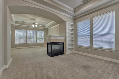 an empty room with windows and fireplace