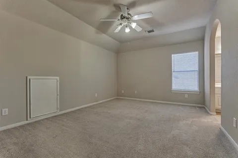 an empty room with a ceiling fan and a window