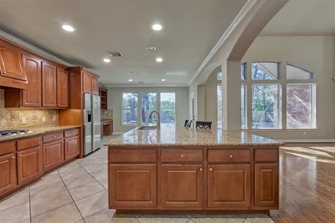 a large kitchen with granite countertop a sink and dishwasher wooden cabinets with granite countertops