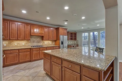 a kitchen with kitchen island granite countertop wooden cabinets a counter top space and a center island