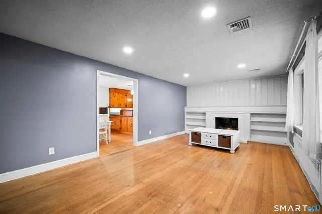a view of empty room with wooden floor