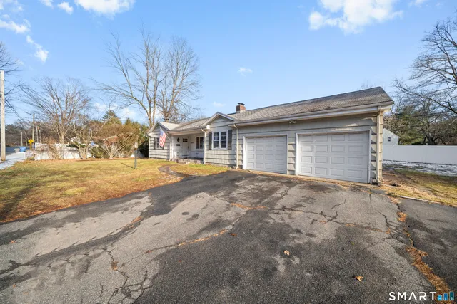 a view of house with yard and trees in the background