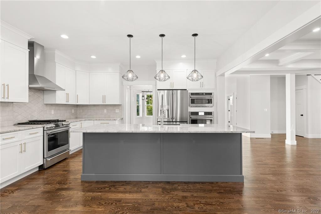 114 Daniel Trace Burlington, CT 06013 - Photo 22 of 30 a kitchen with stainless steel appliances granite countertop a sink a stove and a wooden floors