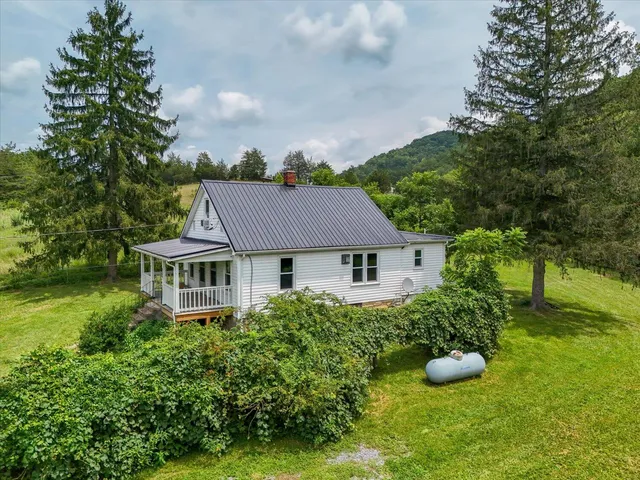 a front view of a house with a garden and trees