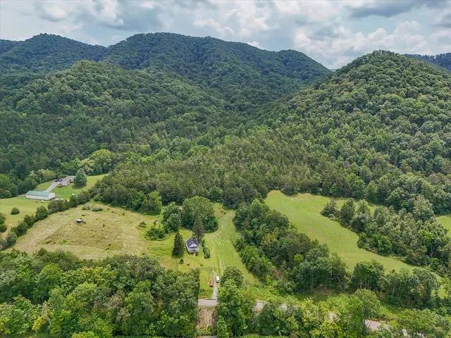an aerial view of a house with a garden and mountains