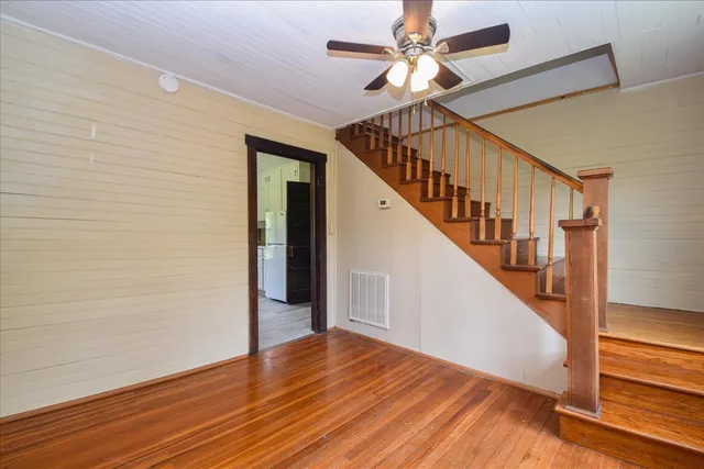a view of staircase with wooden floor and white walls